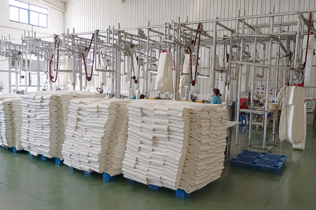 Industrial filter bag manufacturing facility with dedicated production lines for custom baghouse filter bags.