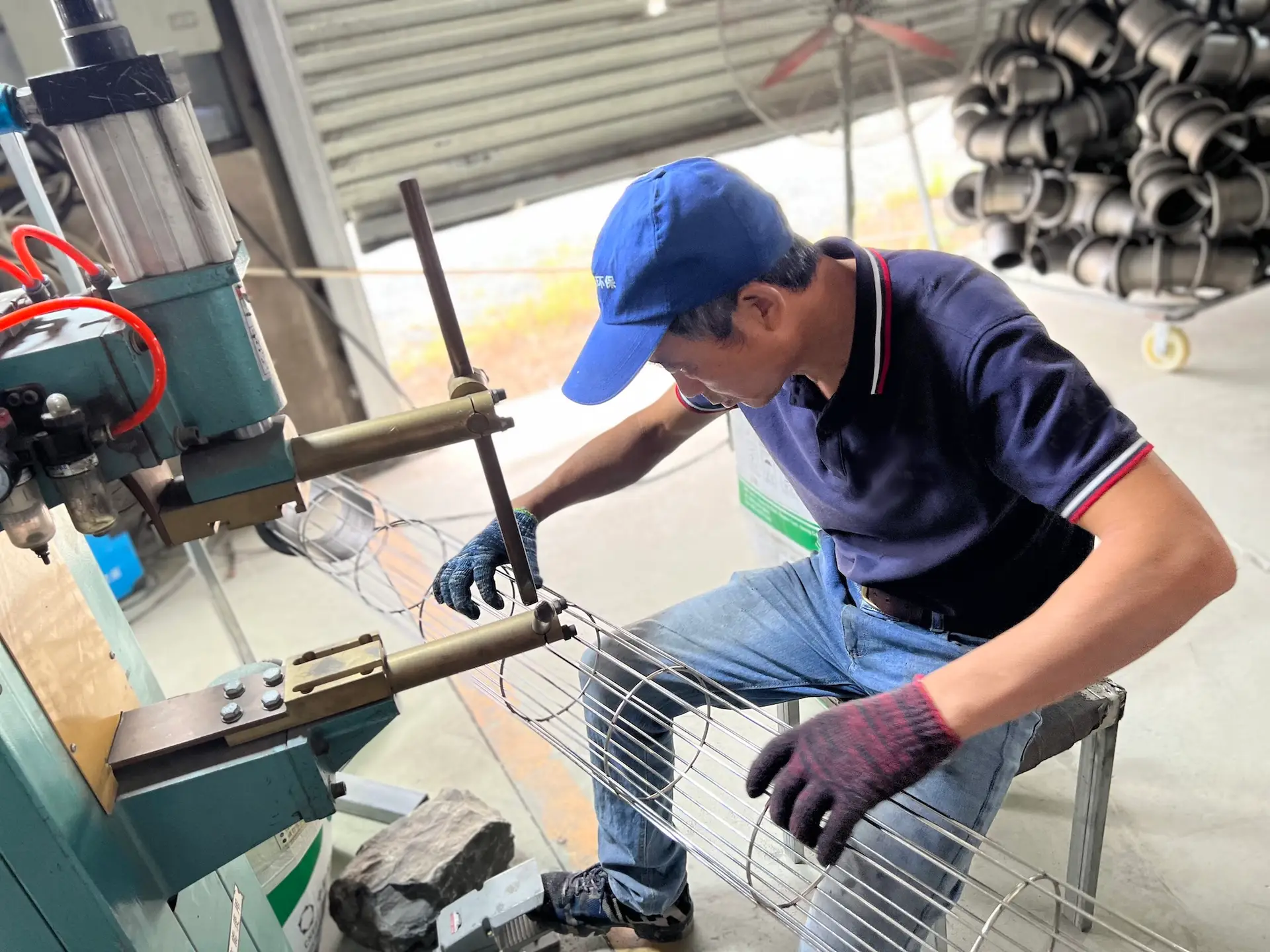 Technician inspecting a custom filter cage during quality inspection before shipment.