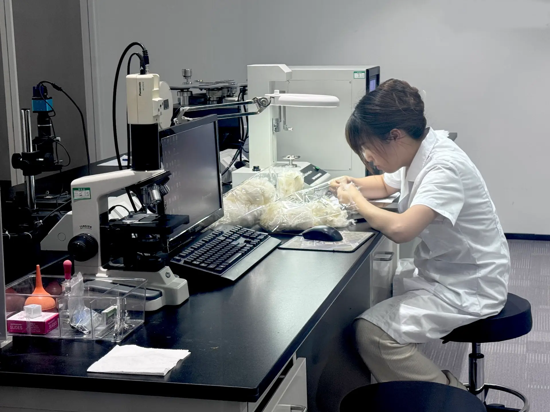 Laboratory technician performing filter media fiber testing to evaluate material properties and support industrial filtration applications.